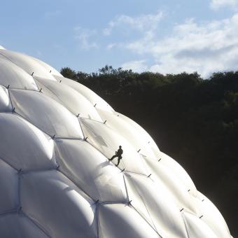 Maintenance person on rope abseiling down the side of a Biome